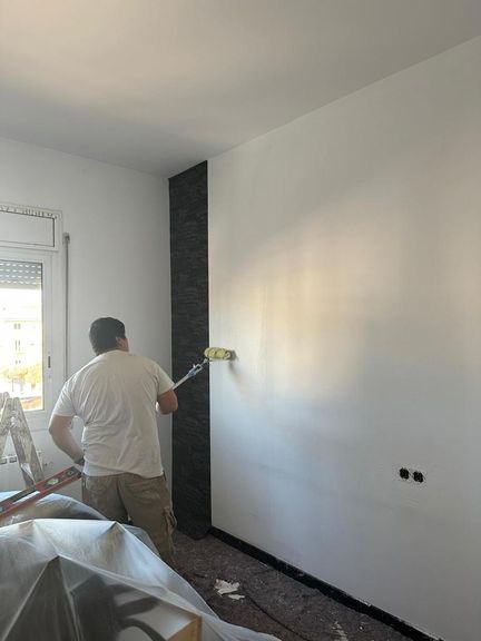 Trabajador pintando pared